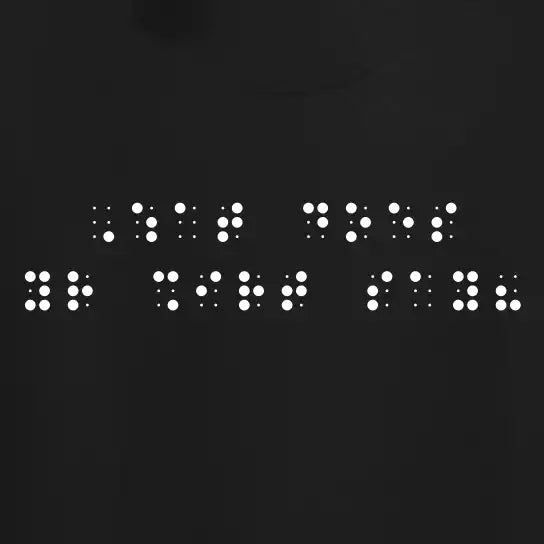 "What does your shirt say?" printed in white Grade 2 braille across the chest of a black t-shirt.