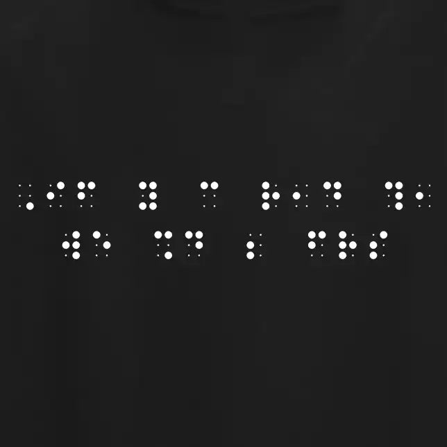 "If you can read this, we should be friends" printed in white Grade 2 braille across the chest of a black t-shirt.